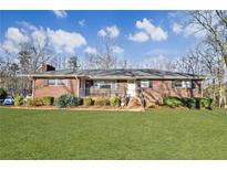 Charming brick home featuring a well-manicured lawn and inviting front porch at 7034 Capps Ferry Rd, Douglasville, GA 30135