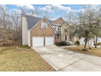 Two-story brick home with a two-car garage and manicured lawn at 6834 Fireside Ln, South Fulton, GA 30349