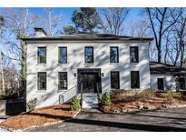 Renovated white brick home with black windows and modern entryway at 7715 Ryefield Dr, Sandy Springs, GA 30350