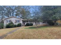 Brick ranch house with covered porch, landscaped yard, and walkway at 3873 Jane Marie Ln, Decatur, GA 30035