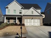 Two-story house with gray siding, brick accents, and a two-car garage at 91 Harris St, Buford, GA 30518