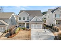 Two-story home with gray siding, brick accents, and a three-car garage at 91 N. Harris St, Buford, GA 30518