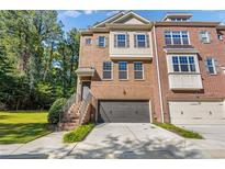 Brick front exterior of charming townhome with attached garage and manicured lawn at 3155 Boldmere Se Trl # 3, Smyrna, GA 30080