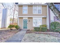 Tan two-story townhouse with green door, walkway, and landscaping at 6414 Wedgewood Trce, Tucker, GA 30084