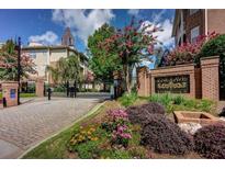 Englave at Renaissance community entrance with gated access, landscaping, and brick architecture at 200 Renaissance Ne Pkwy # 305, Atlanta, GA 30308