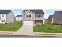 Two-story home with gray siding, brick accents, and a two-car garage at 524 Vervain Drive, Locust Grove, GA 30248
