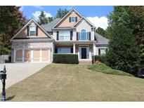 Two-story house with brick and siding, three-car garage, and landscaped yard at 162 Gainesborough Dr, Dallas, GA 30157