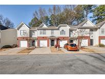 Front view of townhouses with attached garages and landscaping at 5321 Sherwin Dr, Norcross, GA 30093