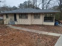 Brick ranch house with covered porch, and landscaped yard at 2838 Ben Hill Rd, East Point, GA 30344