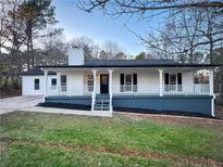 Newly renovated ranch home featuring a charming front porch and landscaped lawn at 1626 Saddlecreek Rd, Auburn, GA 30011