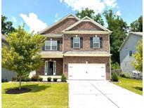 Two-story brick home with a large front yard and driveway at 1140 Sycamore Creek Trl, Sugar Hill, GA 30518