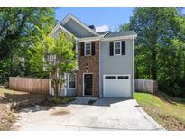 Two-story house with gray siding, brick accents, and a white garage door at 4266 Cabretta Se Dr, Smyrna, GA 30080