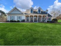 Two-story house with gray siding, brick accents, and a covered porch at 4248 Hog Mountain Rd, Hoschton, GA 30548