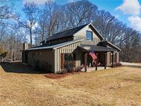 Modern farmhouse exterior with covered porch and large windows at 4258 Hog Mountain Rd, Hoschton, GA 30548