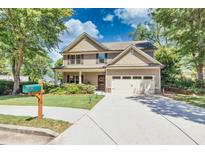 Two-story house with beige siding, a large driveway, and a well-manicured lawn at 510 Church St, Buford, GA 30518