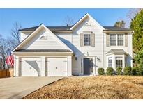 Two-story house with white siding, two-car garage, and landscaped yard at 5720 Millstone Dr, Cumming, GA 30028