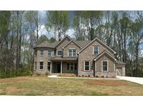 Stunning two-story brick home with a turret and well-manicured front lawn, surrounded by mature trees at 4050 Sierra Vista Cir, Cumming, GA 30040
