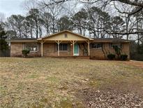 Brick ranch house with a large front yard and mature trees at 2001 Chestnut Log Dr, Lithia Springs, GA 30122