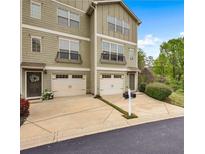 Townhome exterior boasts two-car garage and landscaped yard at 1689 Liberty Nw Pkwy, Atlanta, GA 30318