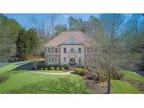 Brick two-story house with a balcony, manicured lawn, and landscaping at 198 Grandmar Chase, Canton, GA 30115