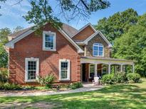 Brick house with stone accents, covered porch, and landscaped yard at 10 Toscanno Dr, Covington, GA 30014