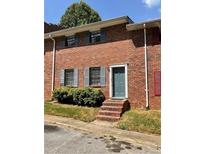 Brick townhouse exterior with landscaping and a teal front door at 6354 Shannon Pkwy # 6D, Union City, GA 30291