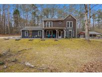 Two-story house with covered porch and landscaping at 114 Delta Ct, Sharpsburg, GA 30277