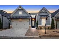 Charming single-Gathering home with gray siding, brick accents, manicured lawn, and a two-car garage at 2540 Village Park Dr, Cumming, GA 30041