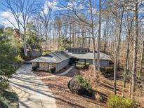 Aerial view of house nestled in wooded lot, showcasing curb appeal and neighborhood context at 220 Mountain Pt, Roswell, GA 30075