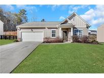 Charming single-story home featuring a two-car garage, manicured lawn, and inviting front entrance at 4770 Marco Ln, Cumming, GA 30028