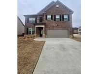 Two-story brick home with attached garage and landscaping at 3462 Hawthorn Farm Blvd, Loganville, GA 30052