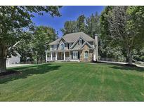 Two-story house with stone accents, front porch, and large yard at 6425 Riley Manor Way, Cumming, GA 30028