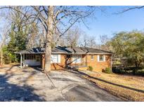 Brick ranch house with a large yard and driveway at 3542 N Druid Hill Rd, Decatur, GA 30033