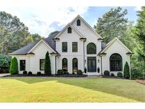 A beautiful two-story home with a manicured front lawn and classic white painted brick at 135 Shadow Creek Chase, Alpharetta, GA 30022