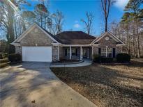 Brick house with a two-car garage and landscaped yard at 3561 Glen Summit Ln, Snellville, GA 30039