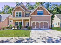 Two-story house with a large front yard, attached garage, and neutral color scheme at 4233 Creekrun Cir, Buford, GA 30519