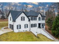 Charming two-story home boasts a classic design with a black roof and shutters and a nicely landscaped front yard at 4492 Bryten Dr, Douglasville, GA 30135