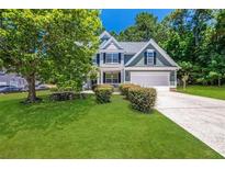 Two-story house with green siding, white trim, and a landscaped lawn at 6196 Windflower Dr, Powder Springs, GA 30127