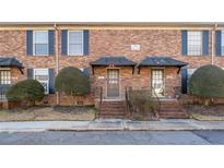 Brick townhouse exterior with landscaping and a walkway at 5667 Kingsport Dr, Atlanta, GA 30342
