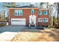 Brick two-story house with attached garage and landscaping at 3125 Oak Meadow Dr, Snellville, GA 30078