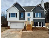 Two-story home with a two-car garage, neutral color palette, black shutters, and wooden steps leading to the front door at 478 Charleston Pl, Villa Rica, GA 30180