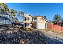Tan two-story house with attached garage and fenced backyard at 3727 Conley Downs Ln, Decatur, GA 30034