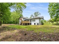 Stunning farmhouse exterior boasts a charming front porch and landscaped yard at 4107 Old Suwanee Rd, Buford, GA 30518