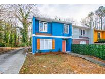 Cute blue renovated duplex with orange door, landscaping, and driveway at 2106 Childress Sw Dr, Atlanta, GA 30311