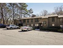 Apartment complex with a large parking lot and well-maintained landscaping with mature trees at 2201 Cumberland Se Ct, Smyrna, GA 30080