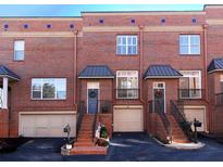 Brick townhome exterior with attached garages and steps leading to the front doors at 62 Emerson Hill Sq, Marietta, GA 30060