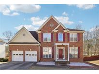 Brick two-story house with a two-car garage and landscaped yard at 2421 Merrion Park Ct, Dacula, GA 30019