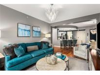 Spacious living room with teal sofa and hardwood floors at 200 River Vista Dr # 427, Atlanta, GA 30339