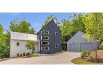 Stunning modern home with two-car garage and unique architecture surrounded by mature trees on a large lot at 160 Cedarwood Ln, Roswell, GA 30075
