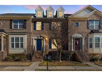 Brick townhouse exterior with blue door, steps, and landscaping at 705 Pecan Knoll Dr, Marietta, GA 30008